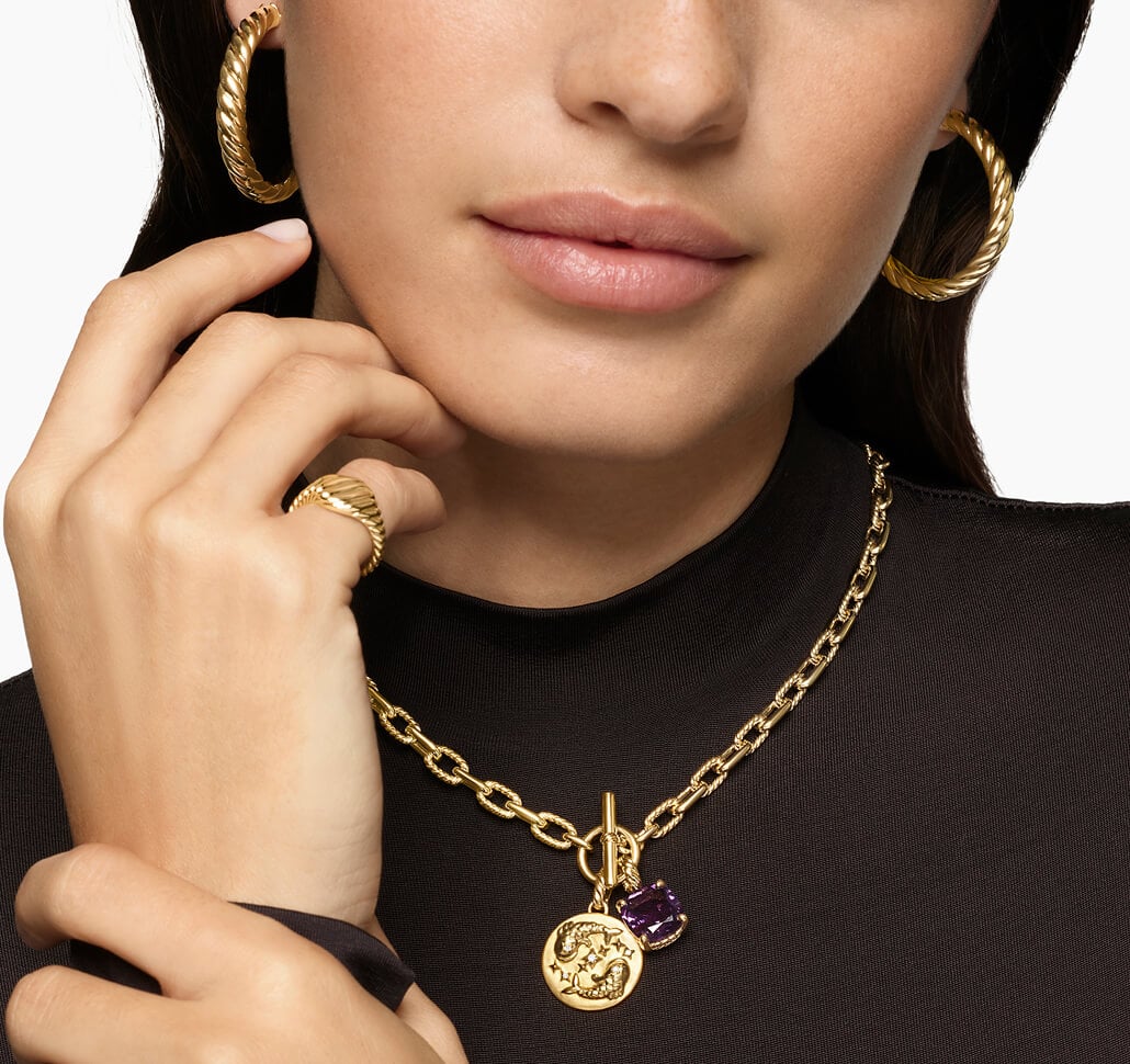 A woman wearing David Yurman charms on a necklace.
