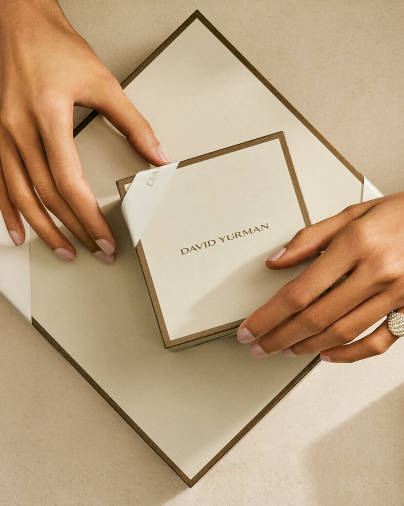 Hands holding David Yurman gift packaging.