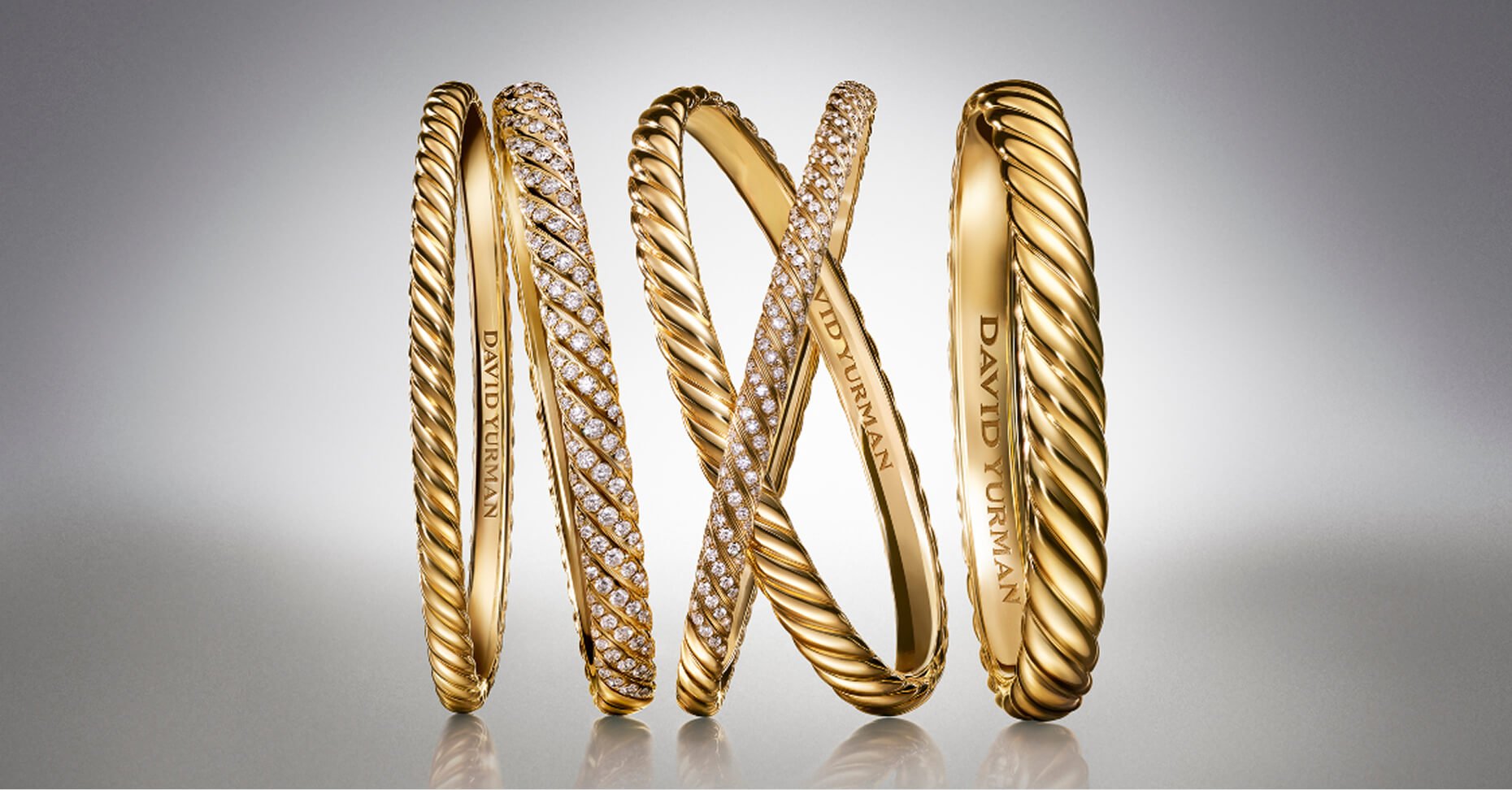 Five David Yurman Sculpted Cable bracelets in gold.